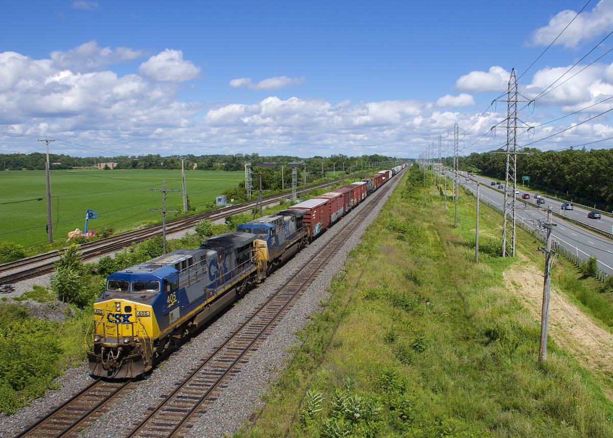 CSXT AC4400CW's 405 & 336 are both in the rapidly disappearing YN2 paint scheme and are arranged elephant style as they lead a 60-car CN 327 through Sainte-Anne-de-Bellevue.