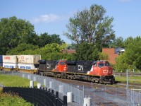 As seen from Montreal's new railfans park by Pointe St-Charles yard, CN 120 passes the entrance to the RTM's maintenance centre, with CN 2231 & CN 2958 up front.