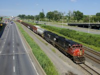 CN 2510 (with the nose door open in deference to a scorching afternoon) and ex-BN SD60M NS 6813 lead CN 527 towards Turcot West with cars from Southwark yard and Pointe St-Charles Yard.