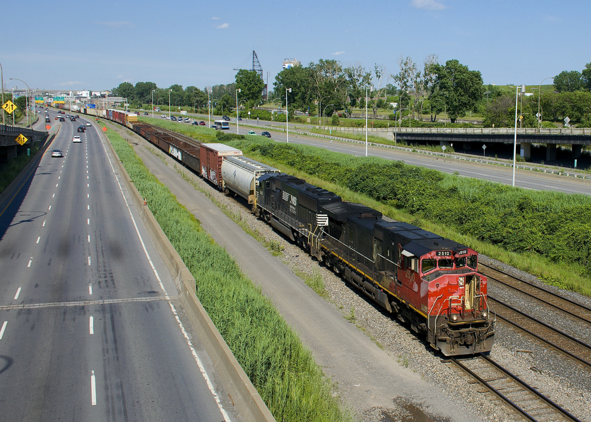 CN 2510 (with the nose door open in deference to a scorching afternoon) and ex-BN SD60M NS 6813 lead CN 527 towards Turcot West with cars from Southwark yard and Pointe St-Charles Yard.