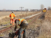 "Severing history" this was a sad day for me. I set my sights on the old CN CASO Subdivision east of Essex. I knew the rail train should be working somewhere that way and exited highway 401 at Tilbury and started checking most crossing west of their in hopes of catching the train. Just west of South Woodslee I finally located the train and it was a slow day of trying to get shots at a few crossings and across farm fields before the long drive back to Milton and that nights, night shift. The long trip rewarded me with a few good shots of something I would never get to do again. Shooting a train on the middle section of the CASO. Once such a mighty railroad with lots of history, today just a fading memory. Here we see one of the track crew cutting the rails at the Lakeshore Road 219 crossing, next the spike pullers will move in before the rail is lifted into place on the rail train. The rail here was apparently reused on a line out in western Canada.