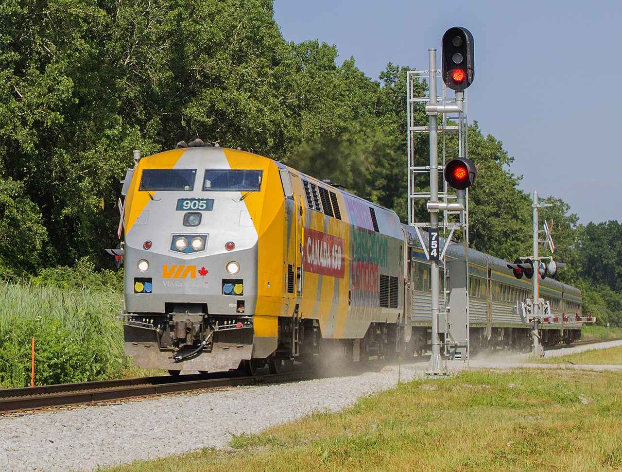 Passing the former station grounds and sidings, Train 73 led by a shiny 905 kicks up the dust as it crosses Jeannette's Creek Road on it's way to Windsor.