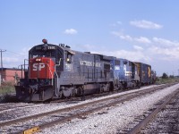 Conrail YDRR-2 has backed down into the interchange to pick up an acid train from the CP. Interesting power for this move included SP 7801, a B30-7 with all the SP additions including an L-shaped windshield, high and low headlights plus the red "emergency light" which illuminated when the train went into emergency braking application (Warned on-coming trains to stop before passing).  In this photo the red light is on. Maybe the CR crew has no idea what its for and don't know how to shut it off.  The CP interchange had four tracks and was adjacent to the Electric Yard whose track are on the right.   