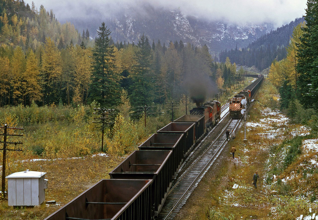 This is a second try to post this picture properly.  In the Selkirks a loaded and empty coal train meet.  As usual the MLW's are smoking it up. Note the crewmen walking towards the highway.  They probably ran out of time and are being relieved.