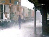 To accompany the <a href=http://www.railpictures.ca/?attachment_id=29684><b>previous photo</b></a> of the operator at Guelph Junction waiting to hoop up orders to the head end of CP #501 on a snowy winter day, here's the operator hooping orders to the tail end crew on the van, as it passes by the station in a flurry of snow.