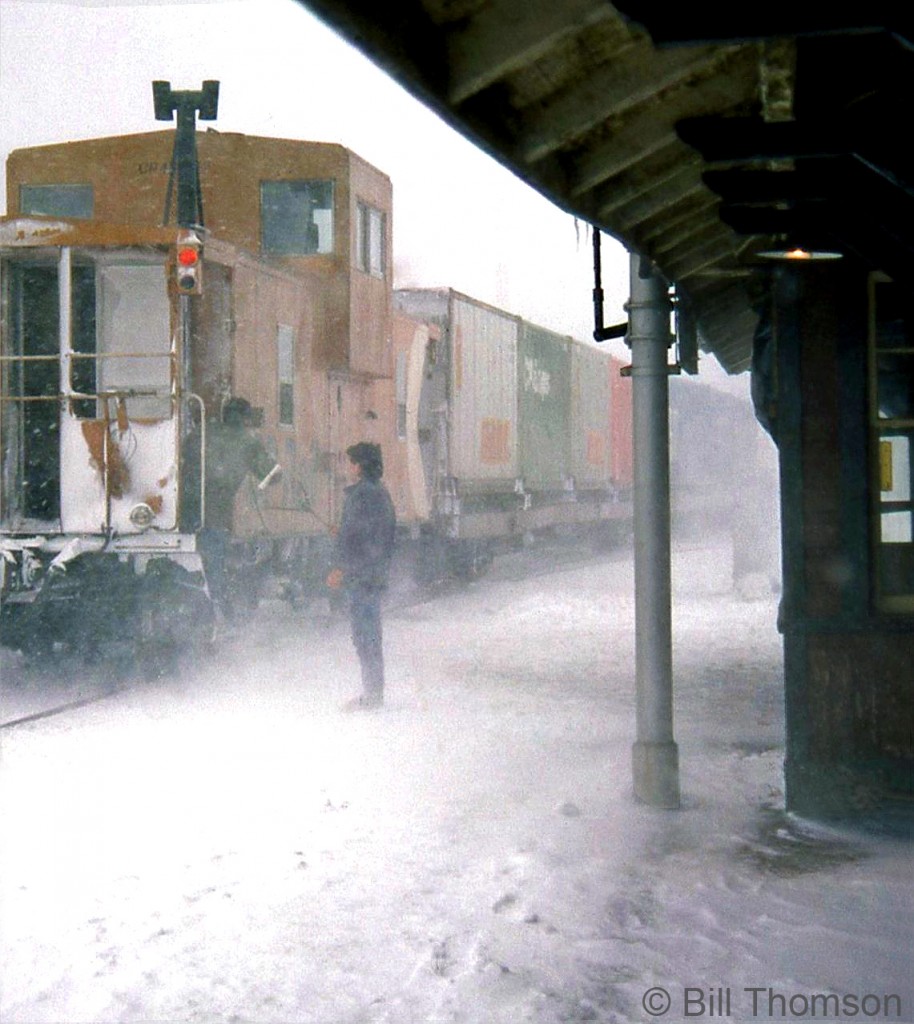 To accompany the previous photo of the operator at Guelph Junction waiting to hoop up orders to the head end of CP #501 on a snowy winter day, here's the operator hooping orders to the tail end crew on the van, as it passes by the station in a flurry of snow.