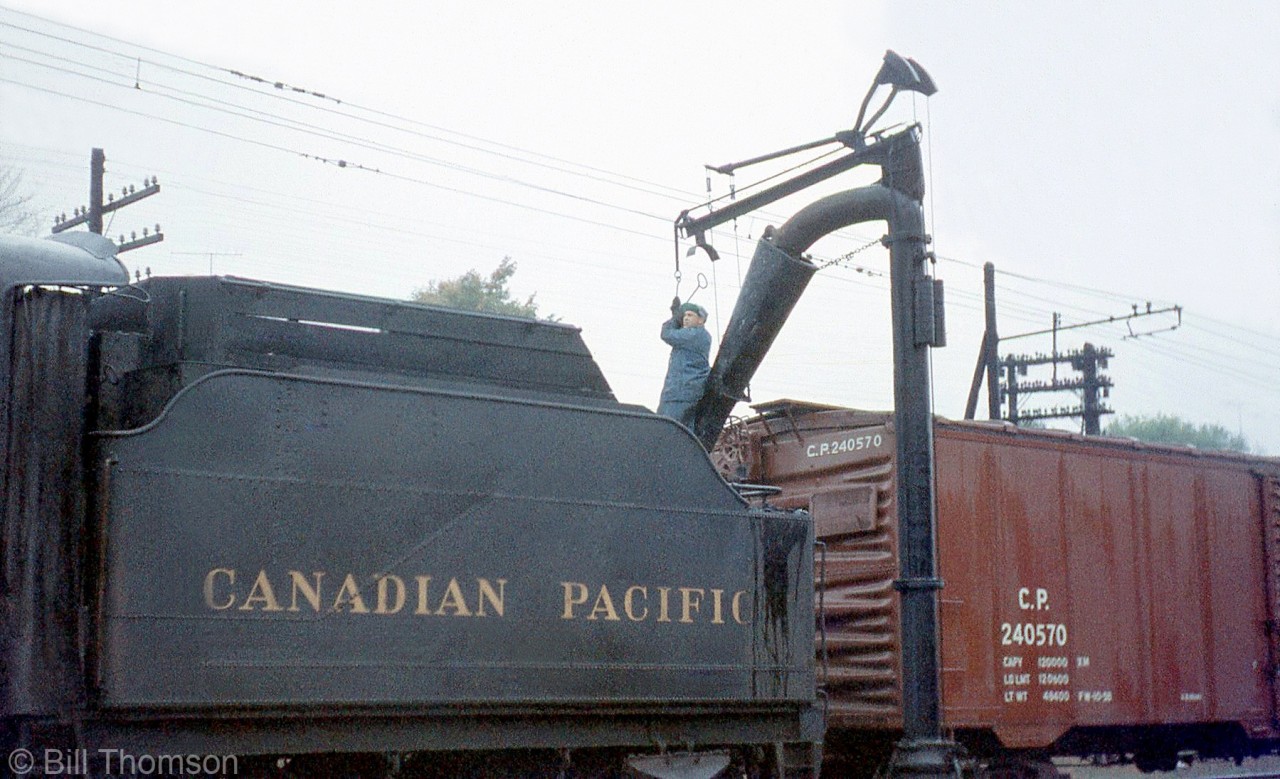 A crewmember sees to filling CPR D10 882's tender with water while stopped at Galt, in October 1959.