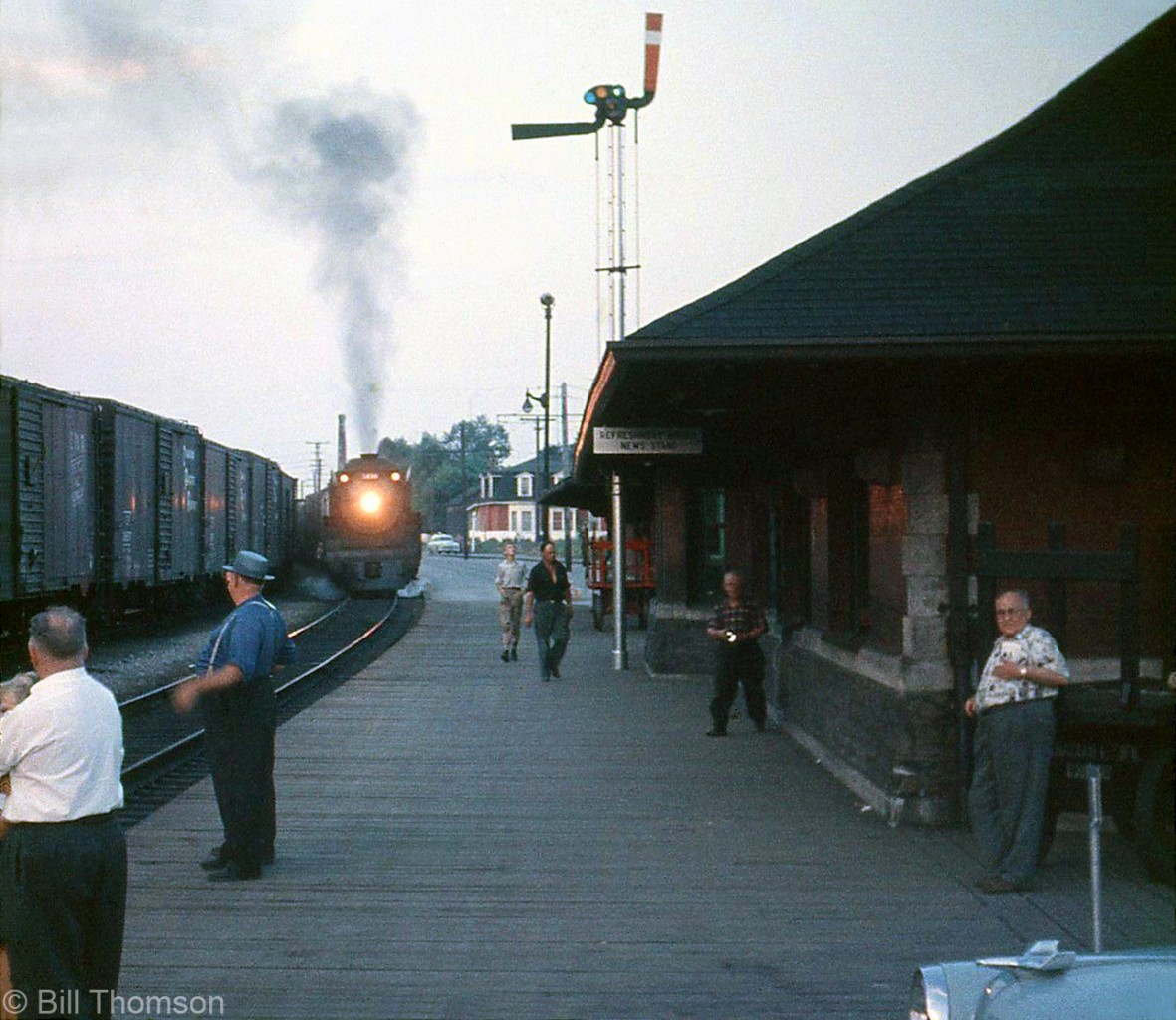 The "Boys down at the Depot" gather to observe an evening meet at Canadian Pacific's Galt Station, with CPR 5419 heading a westbound meeting an eastbound freight in 1959.