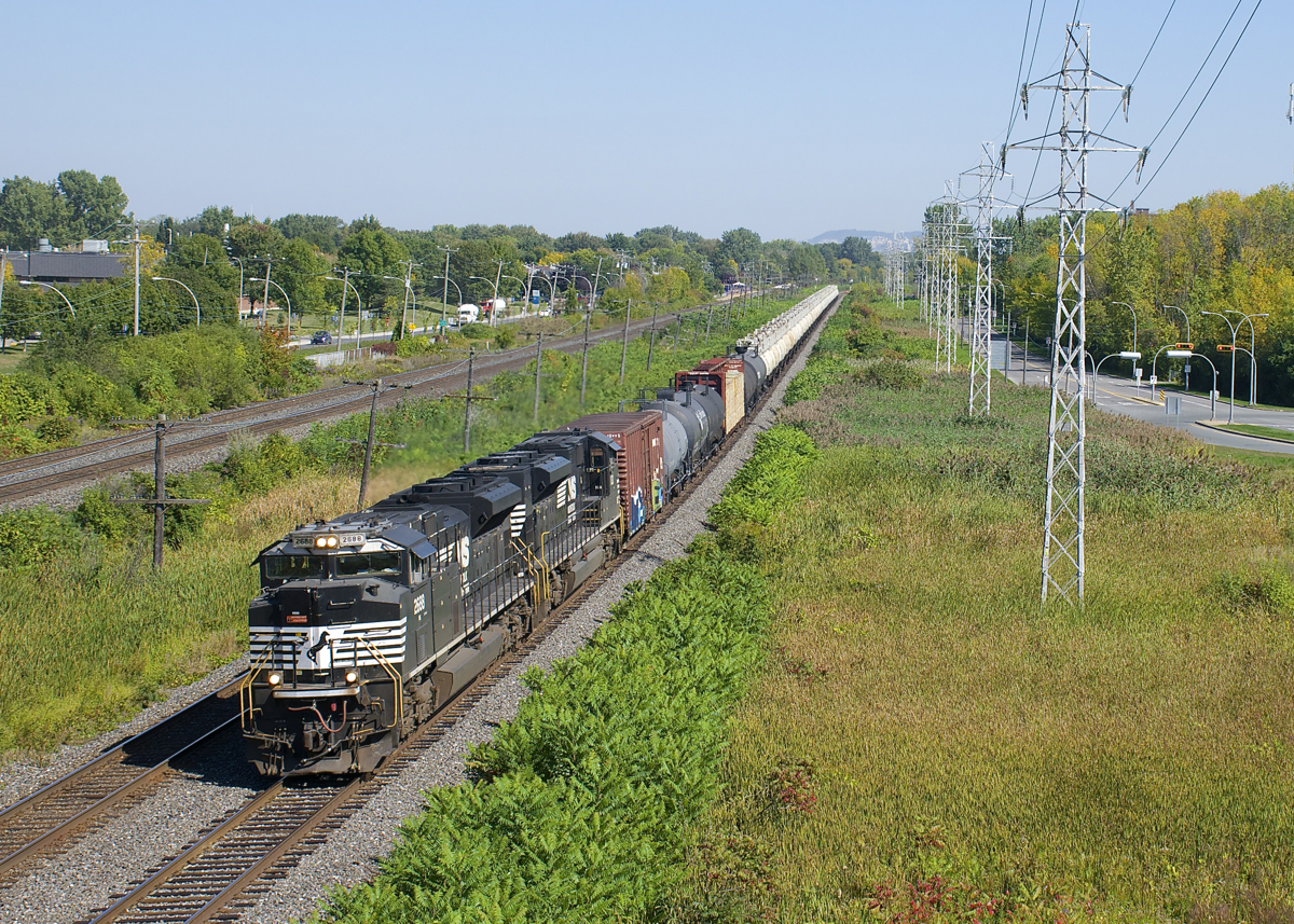 CN 585 (normally a night train in the Montreal area) is approaching MP 14 of CN's Kingston Sub with two NS EMD units (SD70M-2 NS 2688 & SD70ACe NS 1133) borrowed from the CN 528/529 pool. The train is mostly composed of loaded TankTrain cars, with a bit of mixed freight up front.