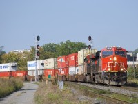 A slightly late CN 120 is rounding a curve in the St-Henri neighbourhood of Montreal with CN 2858 & CN 2824 up front and DPU 3051 for power. This long train is 666 axles long and has 222 platforms. At left the south track is lined for VIA 65.