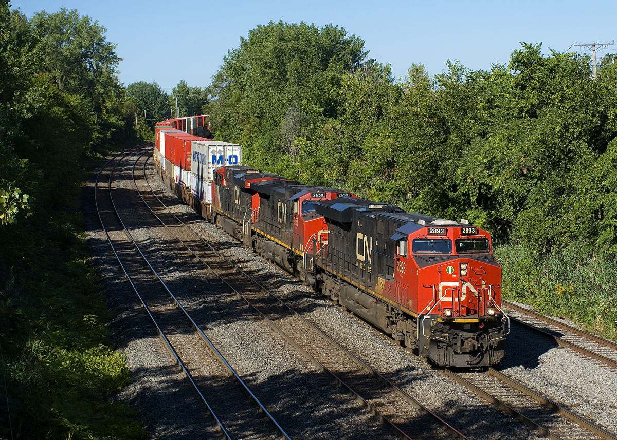 CN 120 (with CN 2893, CN 2658 & CN 2956 up front and CN 2858 mid-train) is rounding a curve in the Ville St-Pierre neighbourhood of Montreal. With the days getting much shorter, shadows are a big problem in this spot, with the power barely avoiding them by luckily being on the freight track.