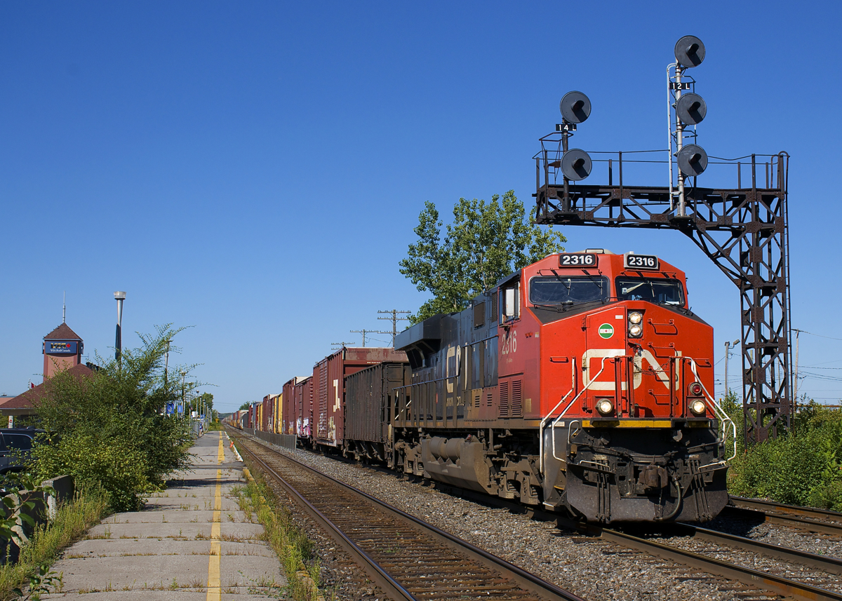 What might be the longest run for a freight train in North America is nearly at an end as Prince Rupert-Montreal stack train CN 186 passes through Dorval Station with CN 2316 at the head end and CN 8010 pushing on the rear. This edition is not a purely intermodal one, with about 20 cars of mixed freight up front.