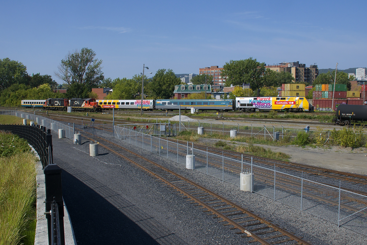 VIA 60 has P42DC class leader VIA 900 as it passes a pair of stopped GP9's (CN 7032 & CN 7075) at the western end of Pointe St-Charles Yard.