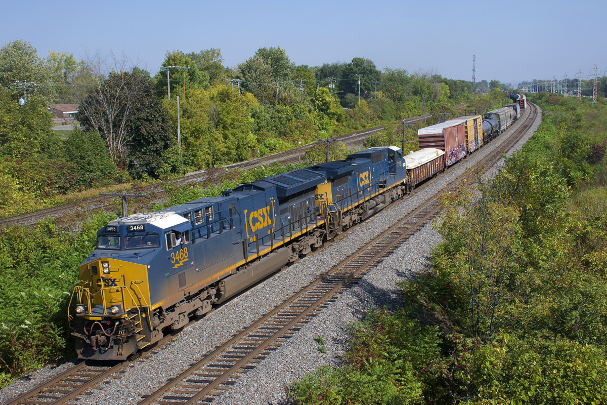 CN 327's conductor waves from the lead unit as the train passes a pedestrian overpass in Beaconsfield. Unfortunately the lead unit had died just a bit east of here; the train would crest the ruling grade west of here at 9 mph before the unit was brought back online at Coteau.
