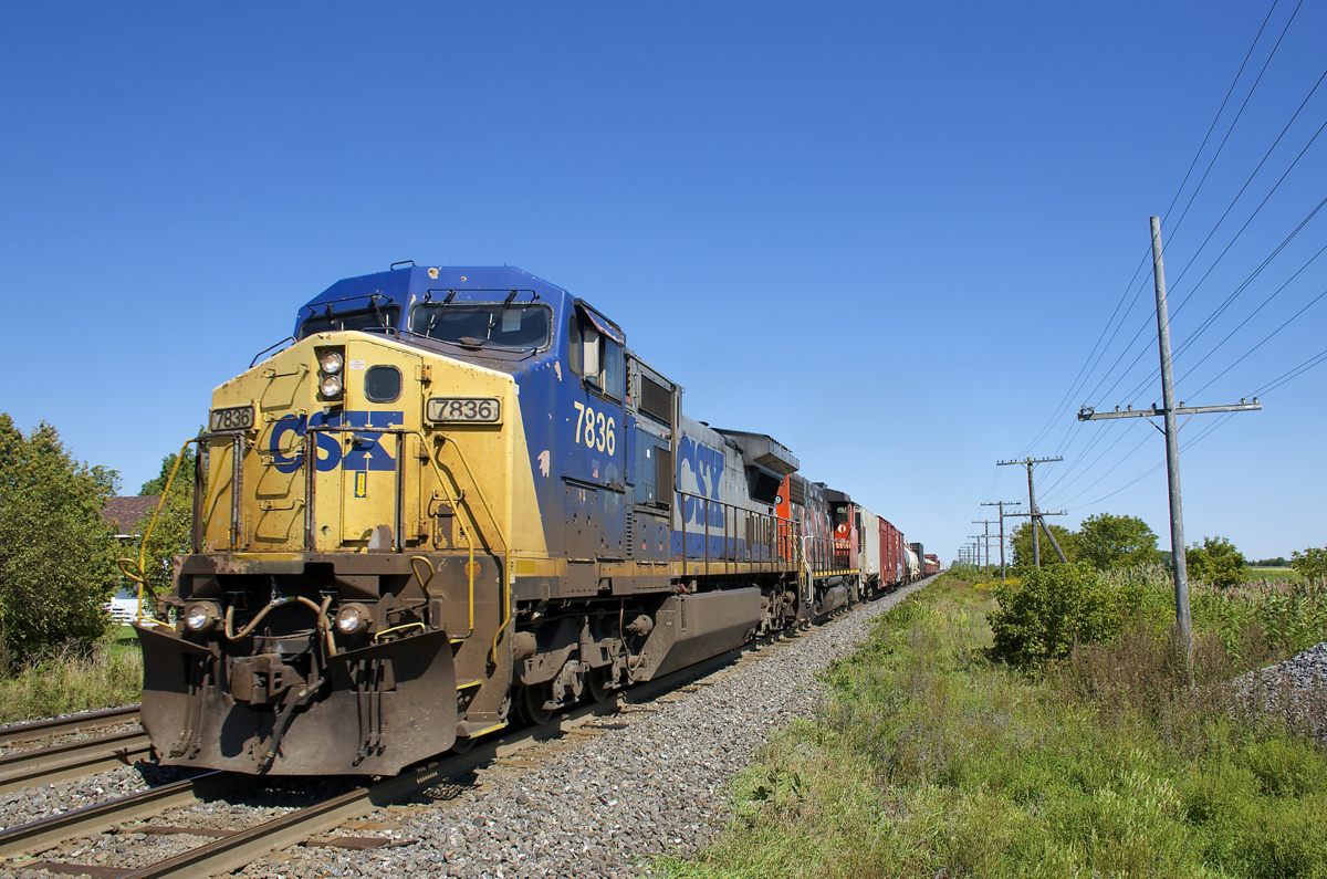 Dash8-40CW CSXT 7836 and GP38-2W CN 4809 lead a 46-car CN 327 towards the St-Dominique crossing in Coteau-du-Lac.
