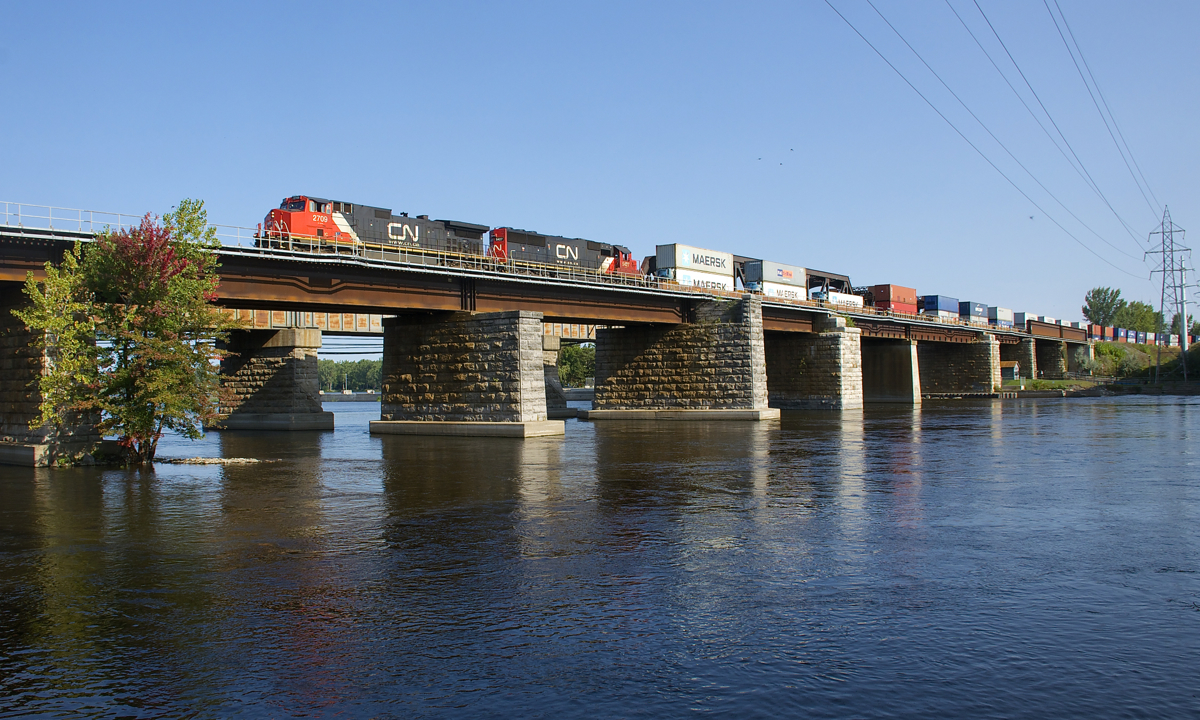 CN 149 is leaving the island of Montreal with containers bound for both Toronto and Chicago on a warm late summer morning. Power is IC 2709 and CN 5427.