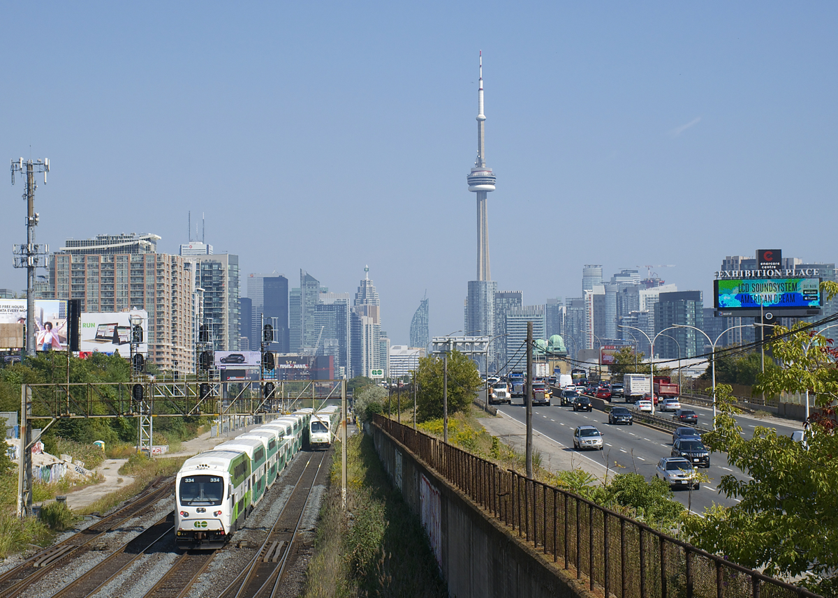 GO Transit has seen an influx of new cab cars over the past year or two, here two meet near Exhibition Station, with GOT 334 at left heading east and GOT 346 at right about to head west. In the background is Toronto's skyline.