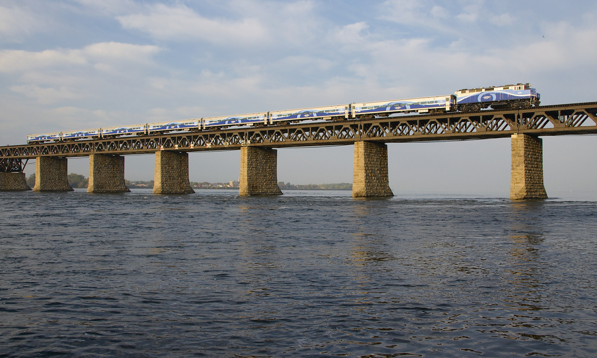 AMT 1342 leads a 7-car AMT 76 towards the island of Montreal on a humid morning.