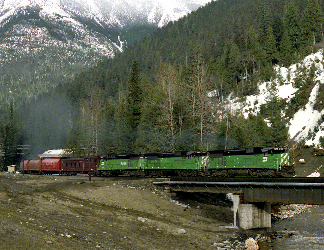 CP was considering buying GE power. During a test a trio of GE Built BN Dash 8's with dynamometer car in tow descends the west slope of Rogers Pass.