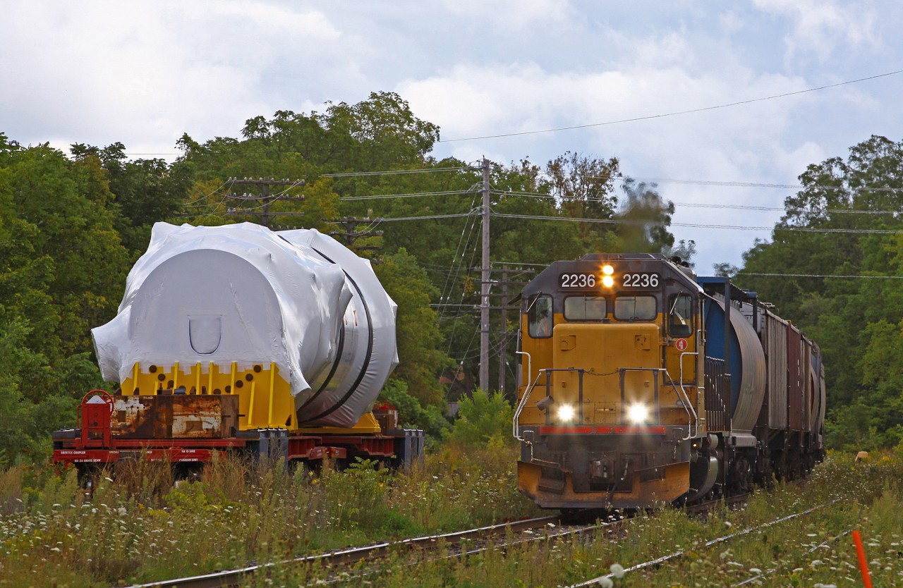 After doubling his 30 ish car train north out of the yard, then having backed it down the east leg of the wye to face the right directing, the not orange LLPX 2236 powers out of Guelph solo on route back to Kitchener. I’m wondering if anyone can shine some light on the Big Thing on two heavy weight flat cars. They appear to have been setting up the area surrounding the cars for trans loading it.