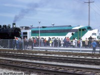 It's April 27th 1974, and crowds are teaming the new GO Transit platforms at Georgetown Station for the inauguration of the new Georgetown line GO train service. Two trains were run that day from Toronto to Georgetown and back for the event: a typical GO train consisting of 10 Hawker-Siddeley single level cars lead by GP40-2W 9808 & APCU 9861 (a rebuilt ex-Ontario Northland FP7), and a steam-powered train of vintage heavyweight passenger cars lead by the Ontario Rail Association's 1912-built ex-Canadian Pacific D10h 1057, lettered for the Credit Valley Railway (the famed steam excursion star that's presently at the South Simcoe Railway).  <br><br> Government and railway officials, passengers, and railfans are all present for the event, including then-Premier of Ontario Bill Davis, who would later climb up in the cab of 1057 and ceremoniously operate it from Brampton (his hometown and where he started his political career) to Bramalea GO station. <br><br> <i>Reg Button photo, Dan Dell'Unto collection.</i>