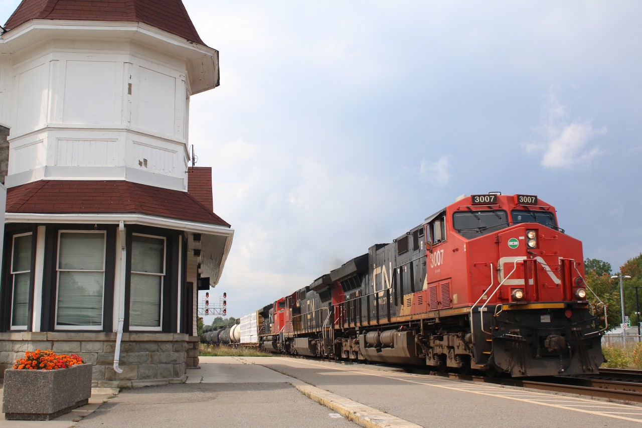 It's the first day of school and autumn is only a few weeks ahead as the sound of a school bell ringing in the distance. CN train 276 is seen passing a planter of orange mums at the shared VIA/GO station in Georgetown, the flowers almost seem symbolic of the fast approaching fall colours and unsettled weather seen in the distance, that will soon become so common. It won't be long now before we hear that feared "F" word, "flurries", LOL.