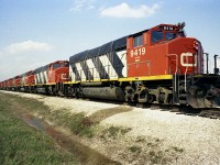 It has been a long time since I shot this photo, just over 41 years ago, and my caption is open to correction. I believe these GP40-2L Widecabs, built in early 1974, are drained and stored due to a downturn of traffic a couple of years later. The column consists of CN 9408 thru 9419, minus the 9412 which was off on another track with long end damage due to a minor derailment of some sort. No idea how long these units remained stored.