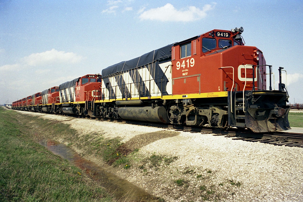 It has been a long time since I shot this photo, just over 41 years ago, and my caption is open to correction. I believe these GP40-2L Widecabs, built in early 1974, are drained and stored due to a downturn of traffic a couple of years later. The column consists of CN 9408 thru 9419, minus the 9412 which was off on another track with long end damage due to a minor derailment of some sort. No idea how long these units remained stored.