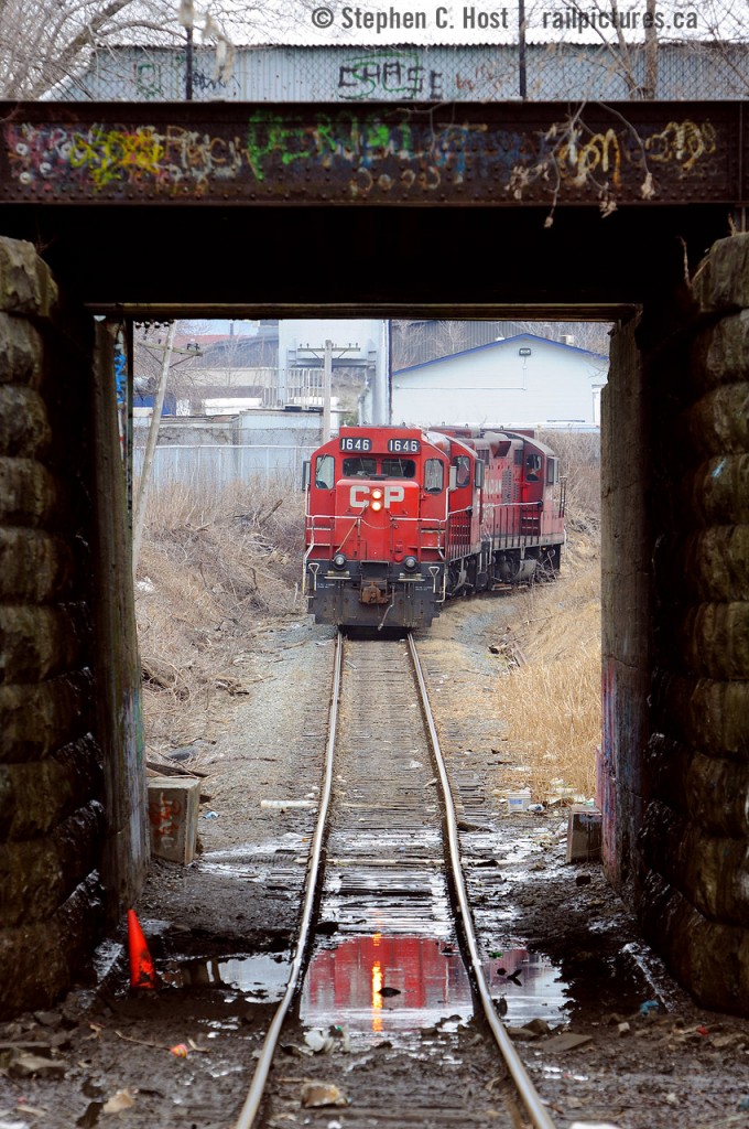 This underpass would have been constructed in 1900 for the TH&B's "new" belt line but the construction screams 30-50 years older, appearing to be made of stone similar to other bridge abutments along the CN (ex Great Western/Grand Trunk) Grimsby sub. Could this have been built far earlier? Regardless, elegant looking abutments meet scummy, dirty, north end Hamilton, this is probably the roughest part of town, Beach Ave by Dofasco, I wouldn't advise going here at night but unlike the US it's probably not all that bad if you don't stand out. I recall there used to be a tavern/strip club type establishment (now demolished) that was known as a druglords paradise (anyone care to rekindle my memory to what it was called?) but for whatever reason I decided to follow this job here for a shot since they were light power, and you just can't stand here with the train coming toward you, you'll get run over - in this shot the train is going away from the camera. I miss the gp9's of course. Hey Snake: This is a steel Steve shot :)