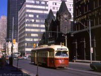 Toronto Transit Commission PCC 4384 passes through the downtown core on King Street, heading westbound just after crossing Simcoe on a King car bound for Dundas West Station.<br><br>It's seen passing the Canadian Pacific Express (originally the Dominion Express Company) offices, part CP's large freight shed complex built in 1914 that dealt with Less-Than-Carload freight and cargo forwarding (transloading between boxcars and trucks for local delivery) located in the King-Simcoe-Wellington-Front area. As other mail express companies came on the scene, along with containerization, railroads moved away from handling LCL freight and the Simcoe St. complex was closed and demolished a few years later in 1977. The property was redeveloped and eventually became home to the new Roy Thompson Hall. St. Andrew's Presbyterian church just behind the streetcar still exists today.<br><br><i>Original photographer unknown, Kodachrome slide from the Dan Dell'Unto collection.</i>