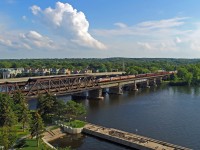 In a scene reminiscent of the Canadian Pacific passenger service glory days, Canadian Pacific 150 Train is entering the Island of Montreal as it crosses the Ottawa River at the historic St-Anne-de-Bellevue Canal, on a warm and humid summer afternoon leading to a stormy evening.