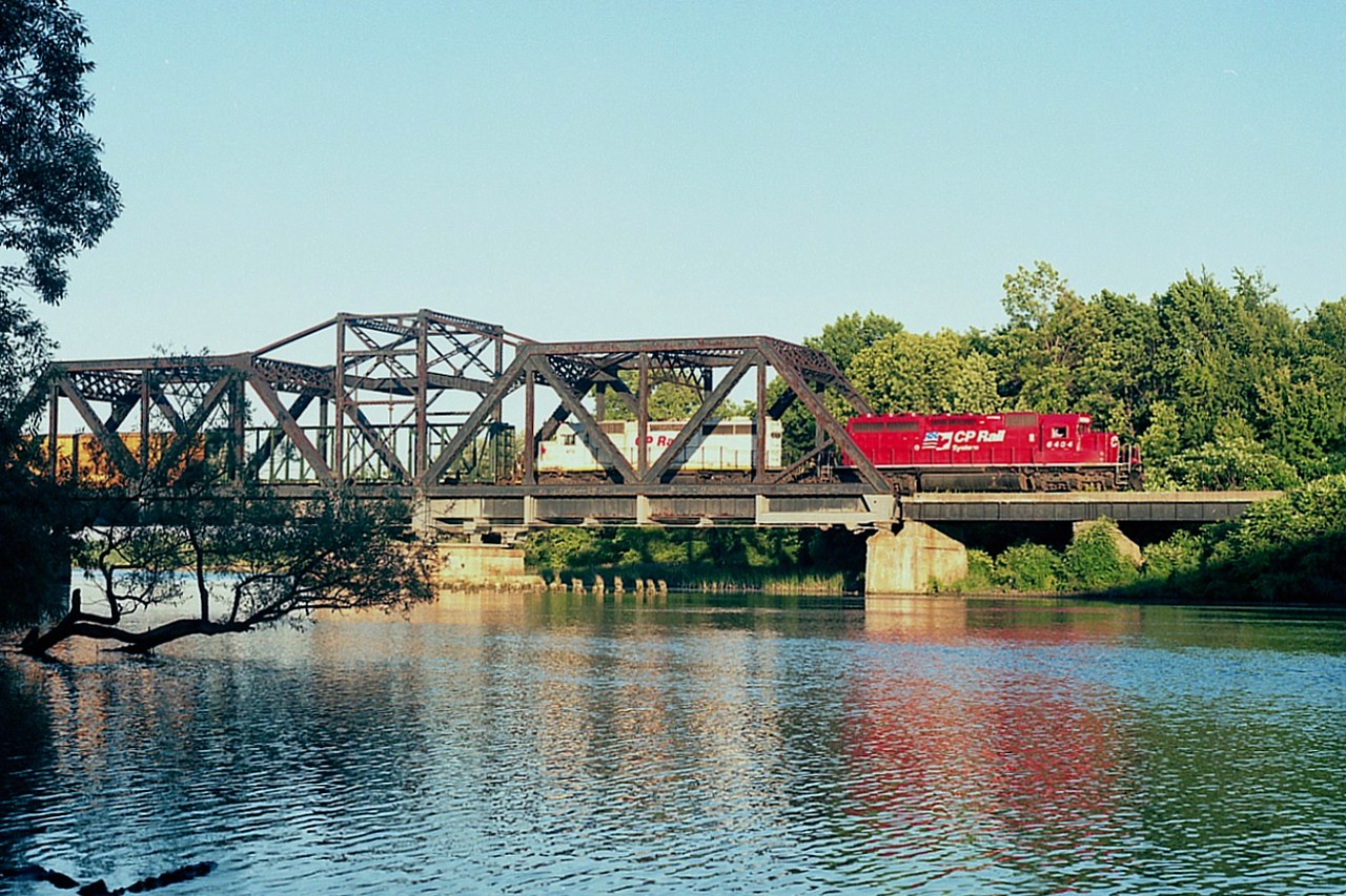It is late in the afternoon as #271, a Saratoga NY to London ON daily (counterpart 270) makes it's way over the steel trestle spanning the Welland River. This structure still exists, just to the east of the QEW at Montrose. It was once the Conrail Mainline, now reduced to the quiet and rarely photographed CP Montrose Spur. It is not an easy place to shoot here, foliage along the river's edge makes finding clearance difficult. On this day we see CP 6404 (formerly SOO, same number) and X-KCS 673 in white as second unit. The 673 was one of 7 purchased from Helm in Dec 1992 and sold to the Bridge Division of CP (D&H). Later on, when the STLH was absorbed back into the CP, it became CP 5418 in the standard red scheme.