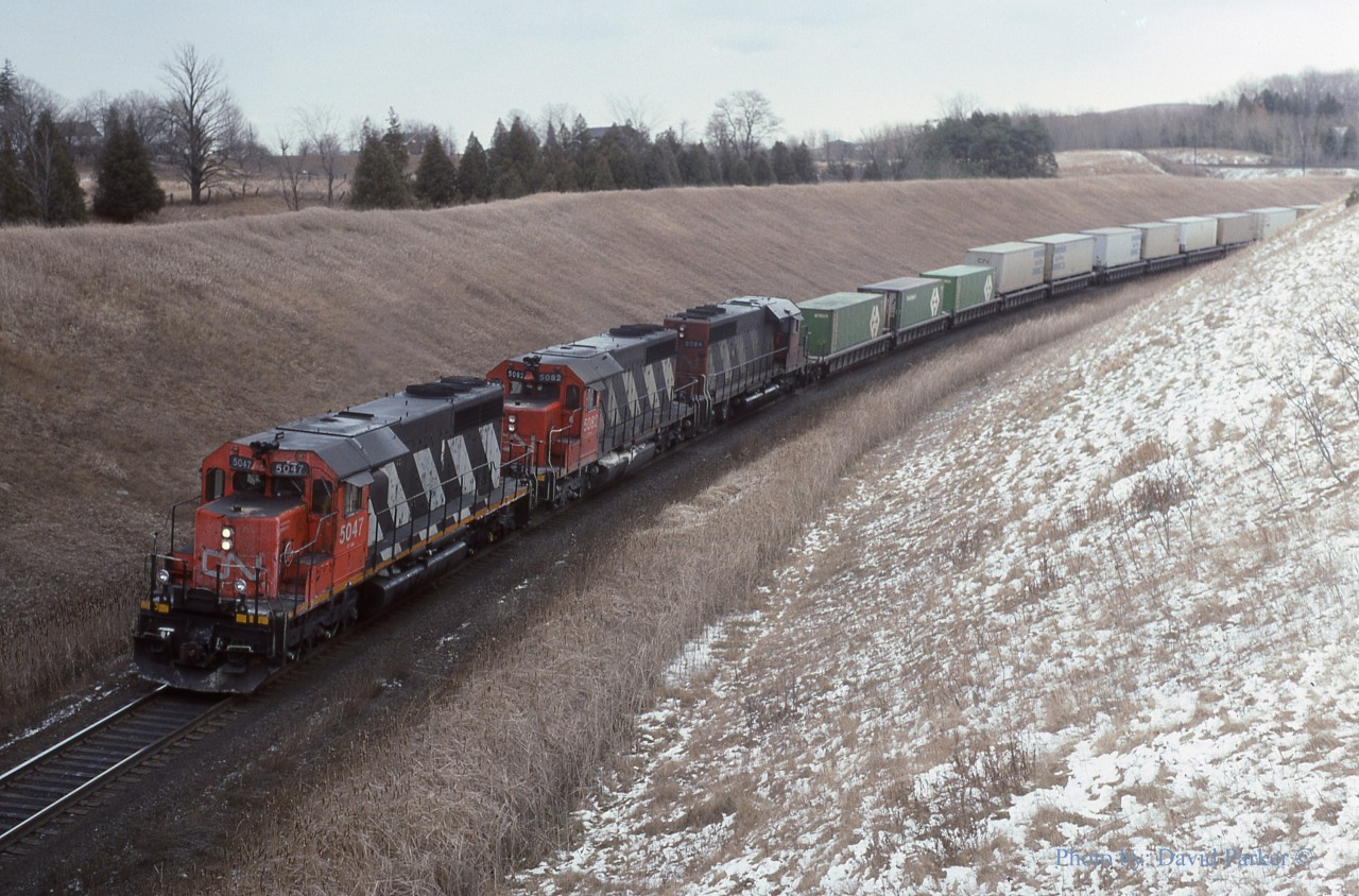 A trio of standard cab SD40's 5042-5082-5084 climbs the grade passing beneath the CP Belleville Sub just West of Beare Siding (Beare is now a spur as the West switch has been removed)