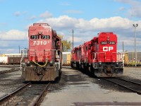 Ex D&H GP38-2 CP 7310 poses beside an original CP ordered Geep. Note the conversion to a single rear headlight and the plentiful numbering on the 7310.
