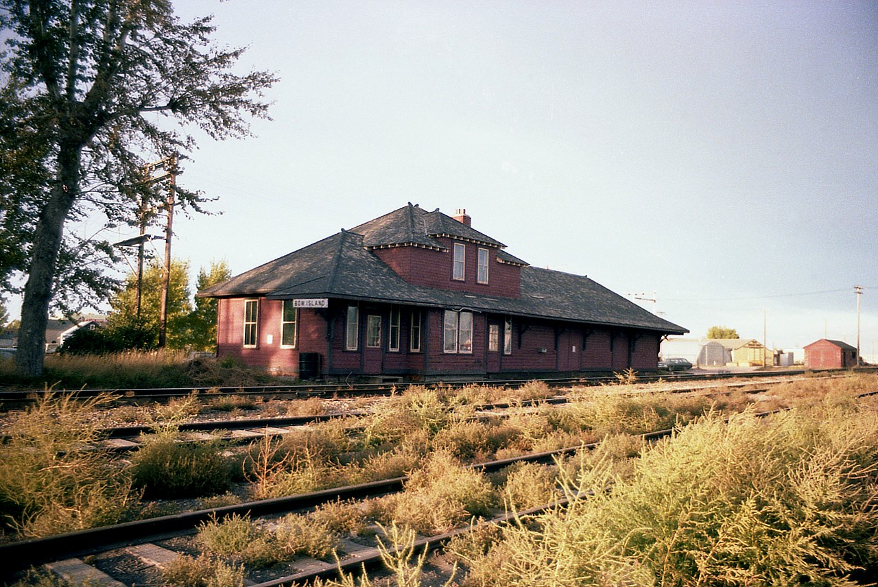 It is late in the summer, beginning fall, and the presence of tumbleweeds give this image a very western flavour.  The old station at Bow Island is an impressive structure, complete with living quarters upstairs for the agent and his family.  One can imagine, though, the relentless frigid winter winds just whipping right thru this old place.  The station still survived in the mid-1990s; it was going to be restored and put to some municipal use, as far as I knew; but a stop in town last fall proved me unable to locate it. I do not know if it has been razed, and if anyone knows this station's demise, please pass along the information !!!!