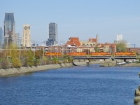 <b>Detour move.</b> Due to a derailment on their bridge between Terrebonne and Laval, the Quebec Gatineau Railway has been running detour trains on CN's main line between Montreal and Quebec City. Here an eastbound detour (IDed CN F900) is crossing the Lachine Canal in St-Henri this afternoon with downtown Montreal in the background. Power is four SD40-3's (QGRY 3347, QGRY 3325, QGRY 3334 & QGRY 3326), with 91 cars in tow.