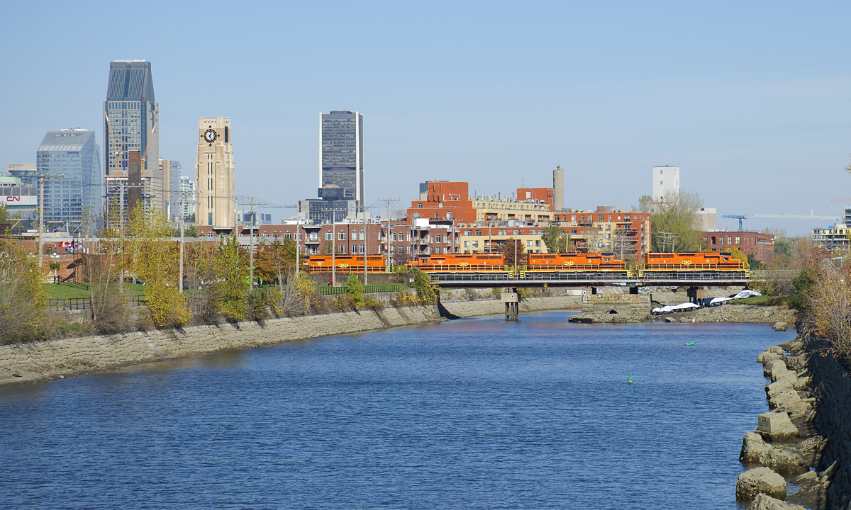 Detour move. Due to a derailment on their bridge between Terrebonne and Laval, the Quebec Gatineau Railway has been running detour trains on CN's main line between Montreal and Quebec City. Here an eastbound detour (IDed CN F900) is crossing the Lachine Canal in St-Henri this afternoon with downtown Montreal in the background. Power is four SD40-3's (QGRY 3347, QGRY 3325, QGRY 3334 & QGRY 3326), with 91 cars in tow.