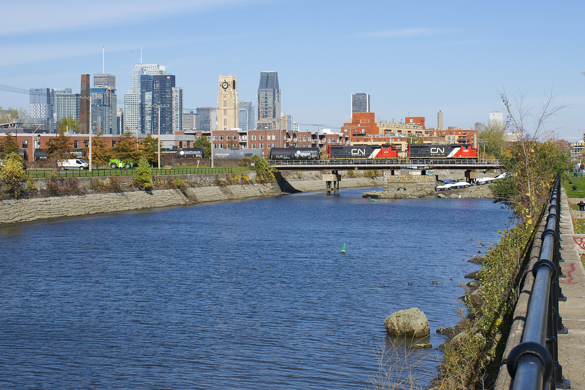 A pair of surprisingly clean and repainted widecab geeps (CN 9584 & CN 4772) lead CN 586 with mixed freight as well as emty TankTrain cars from Brockville over the Lachine Canal about ten minutes after QGRY detour CN F900 passed.