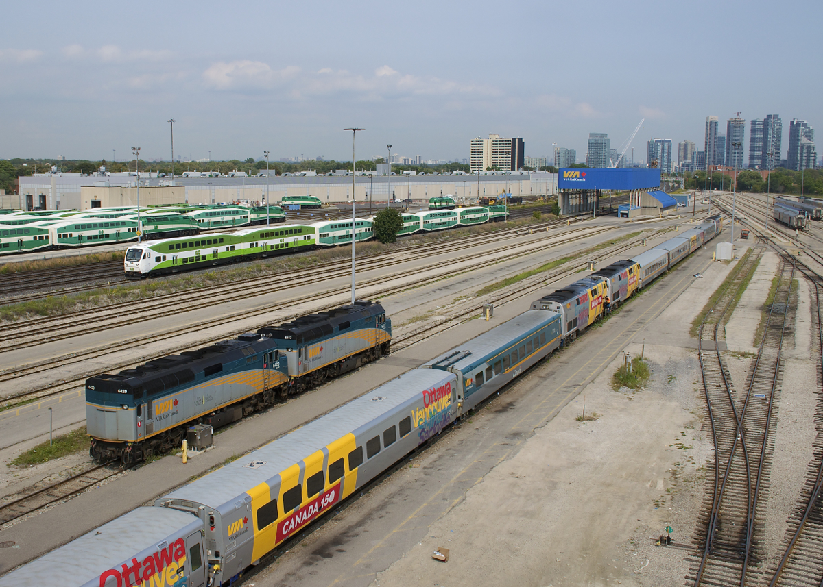 Cab car GOT 331 leads a deadhead move west past a pair of F40's (VIA 6417 & VIA 6420) which are heading east light and some parked VIA Rail equipment at the Toronto Maintenance Centre. On the other side of the Oakville Sub is GO Transit's Willowbrook maintenance facility