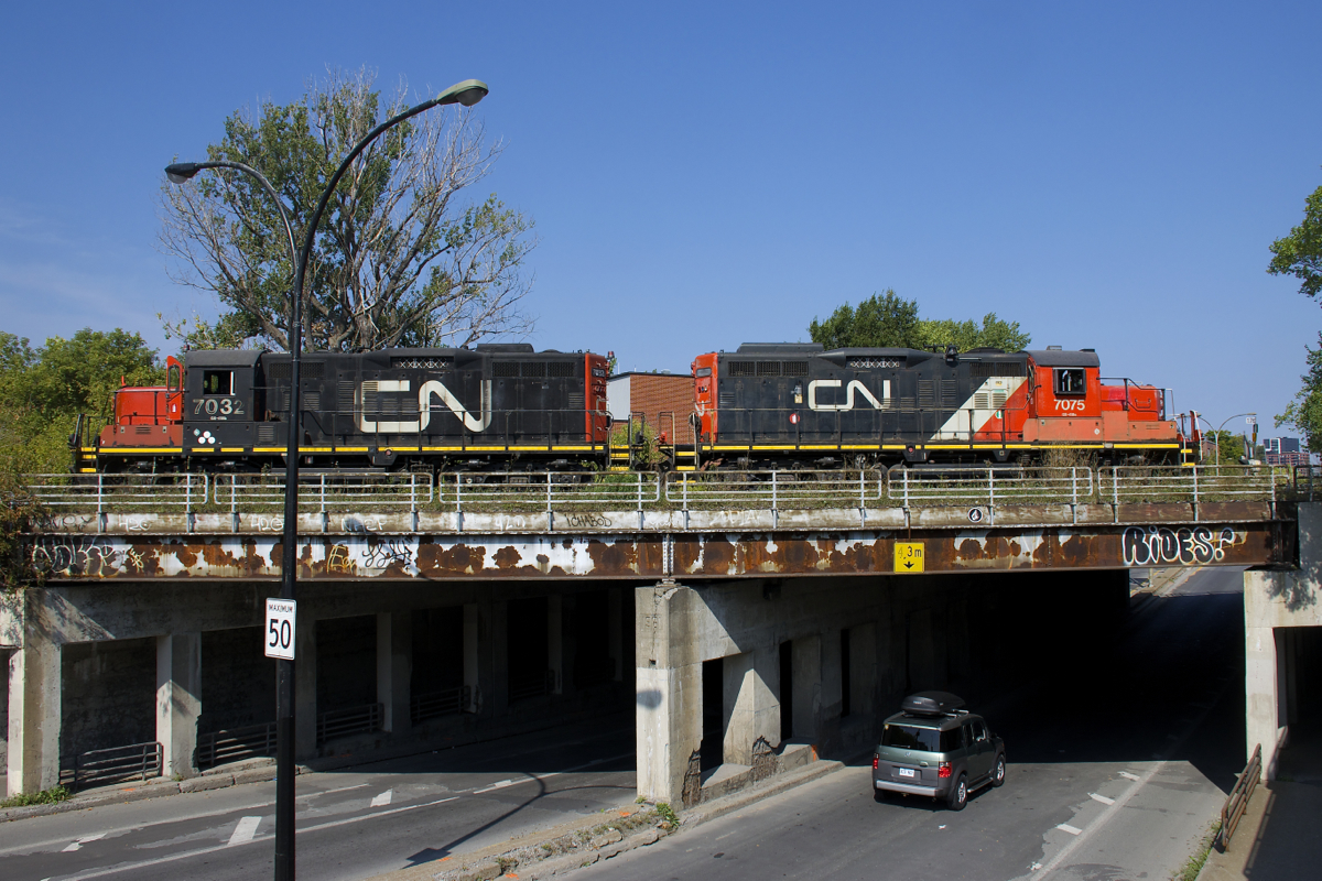 A pair of GP9's (CN 7075 & CN 7032) work the Pointe St-Charles Yard as they cross Wellington Street.