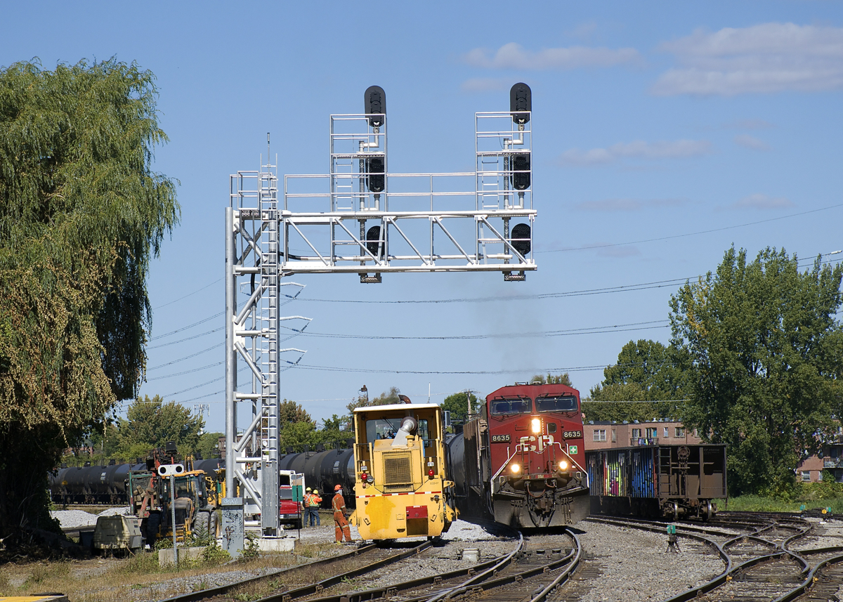 Loaded ethanol train CP 650 with CP 8635 leading is passing a dynamic track stabilizer by Lasalle Yard. Normally CP 650 is on the west track of the CP Adirondack Sub but with quite a bit of work on the west track it's running on the east track. At right are four multimarked but heavily tagged CP hoppers.