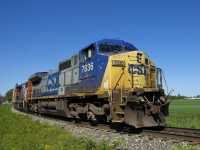 The paint on both Dash8-40CW CSXT 7836 and GP38-2W CN 4809 has seen better days as they lead a 46-car CN 327 off the Kingston Sub and onto the Valleyfield Sub, with loaded centrebreams with export lumber at the tail end barely visible at far right.