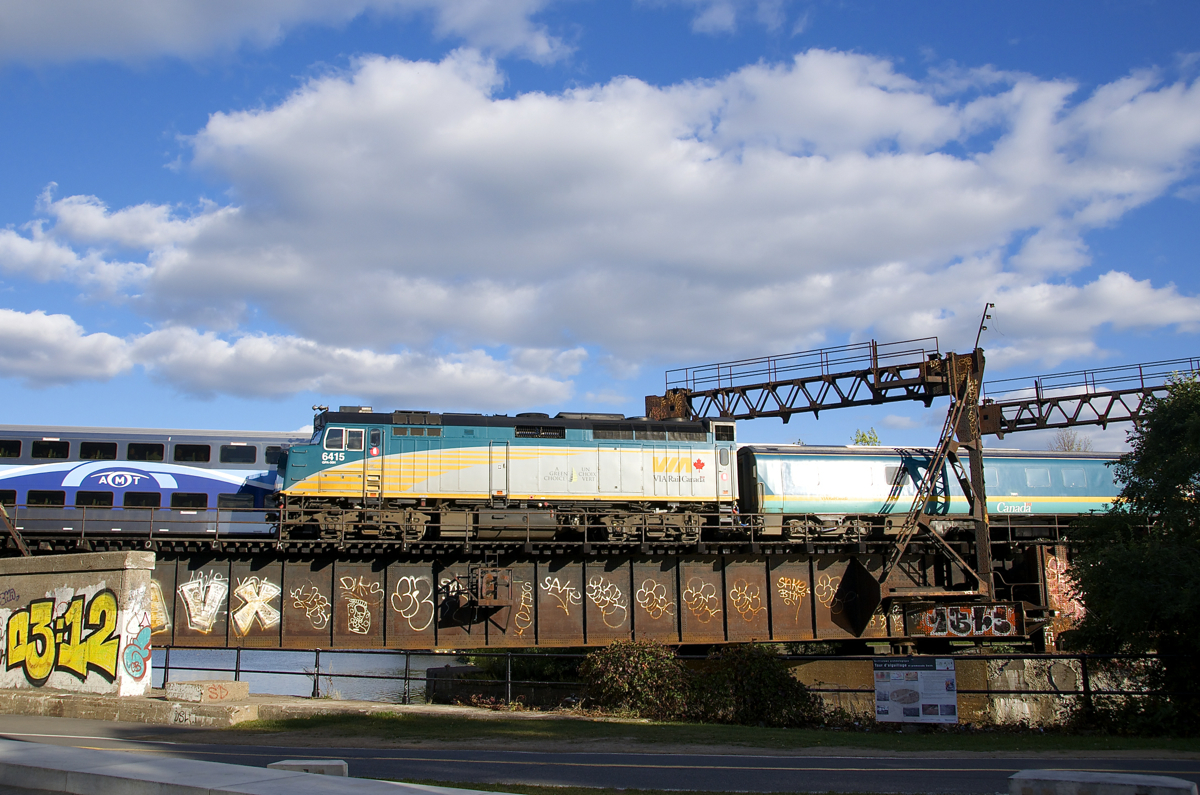 Both AMT 814 and VIA 37 are crossing the Lachine Canal after leaving Central Station more or less simultaneously. VIA 37 has VIA 6415 pushing the train as it backs out, in not too long the train will change directions and head towards Ottawa.