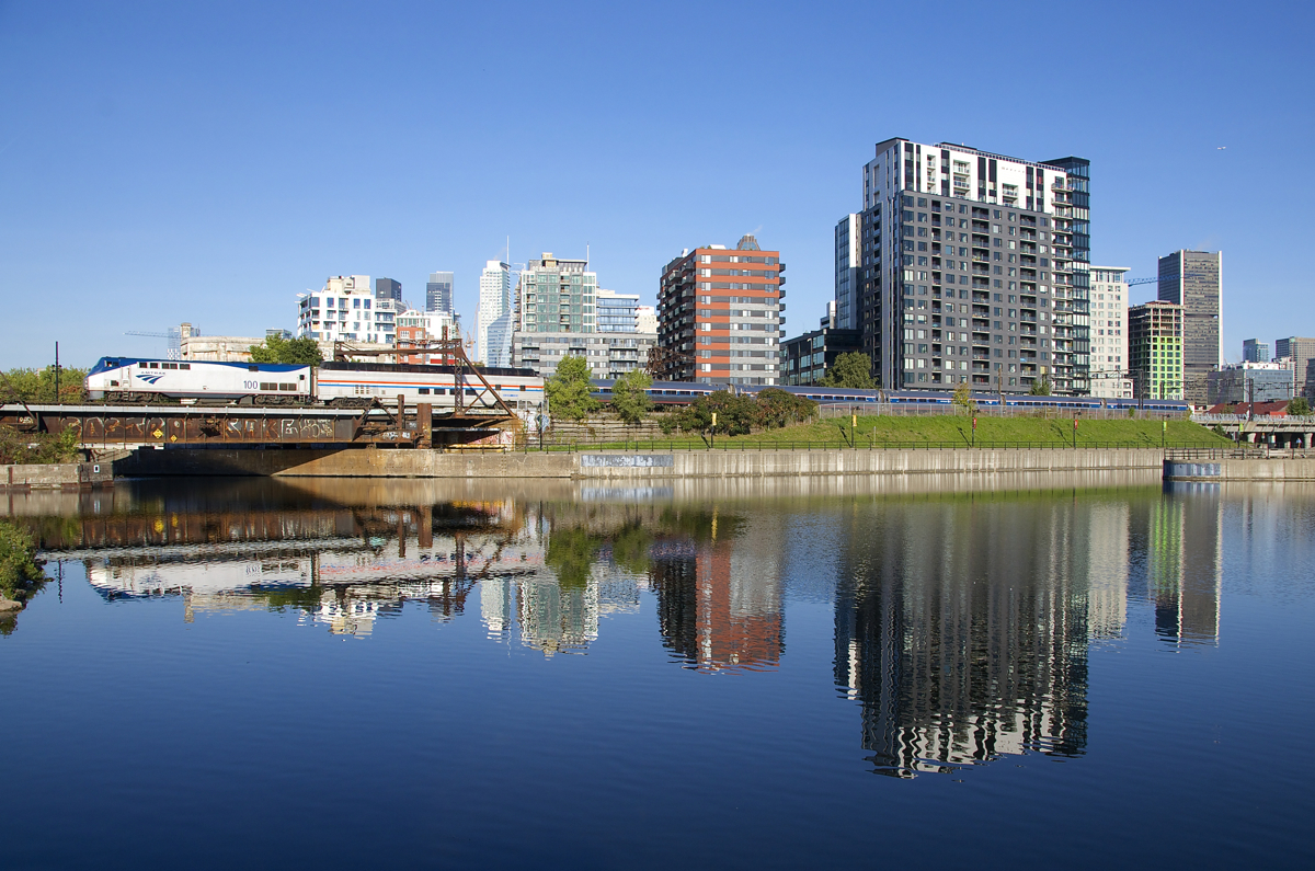 As happens every fall, the Amtrak Adirondack has the great dome car Ocean View for a month, three times a week northbound and three times a week southbound. Here the train deadheads towards Montreal's Central Station about eighty minutes before its departure, passing the Peel Basin, where a number of condos and hotels are reflected in the fairly still waters.