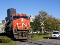 CN 2262 is in charge of CN 149 as it approaches the last crossing in the Port of Montreal, flagged by a Port of Montreal employee whose truck is parked at right.