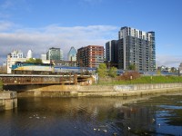 VIA 63 has VIA 6413 leading the usual seven stainless steel coaches as it crosses the Lachine Canal and passes Wellington Tower.