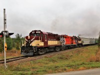 A pair of old MLW's sandwich and even older GMD in this consist from the 1950's. GJR 182 leads GJR 1591 and GJR 505 across the First Line Nassagaweya on their way to Guelph on a rainy, damp day.