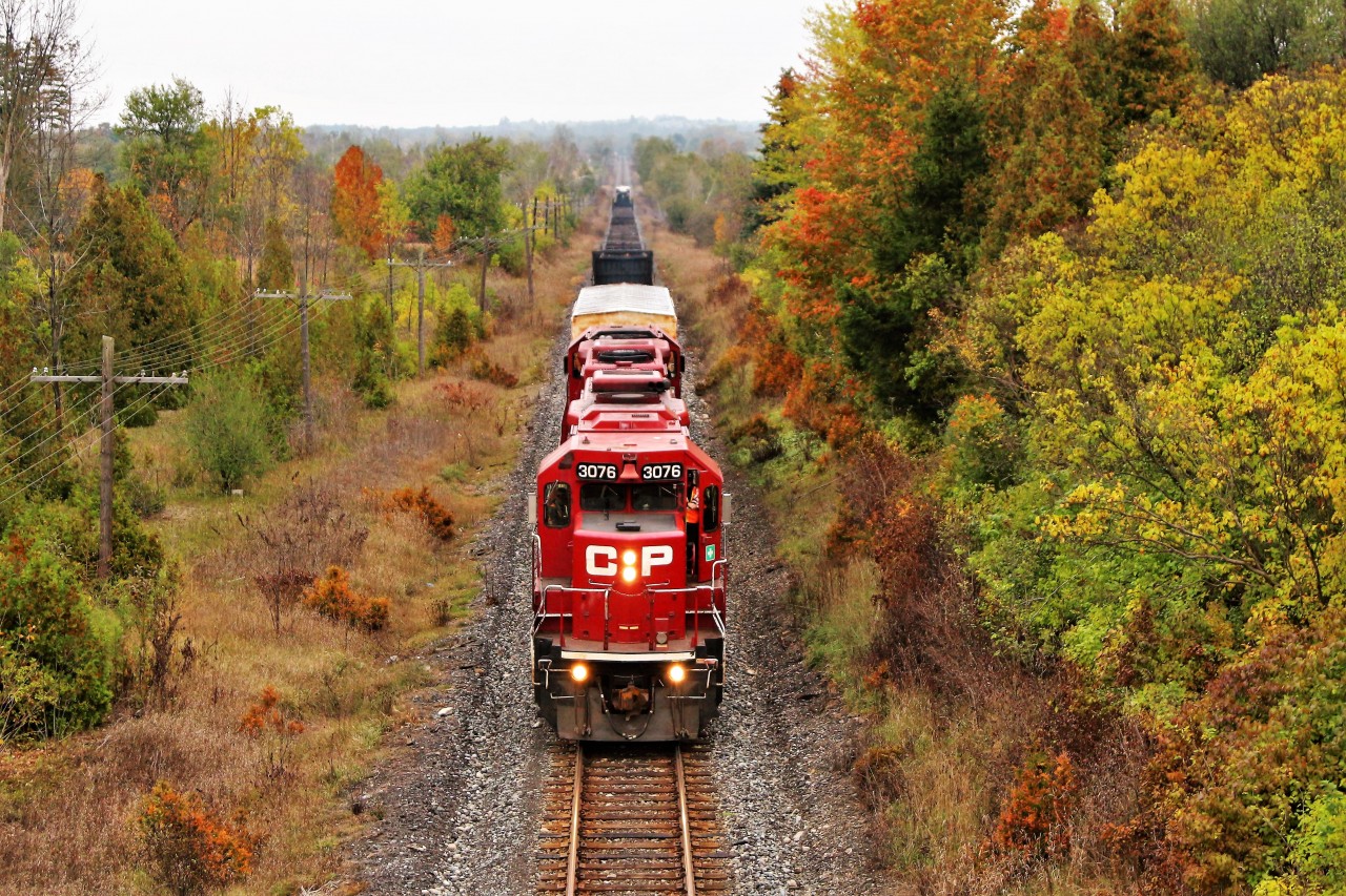The rail train led by a pair of GP38-2's in CP 3076 and CP 3097 slowly climbs the grade as they roll up to the Highway 6 overpass as the drizzle and fog move in. The conductor is exiting the train to make the switch to go in to the Puslinch siding to allow T69 to pass.