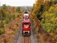 The rail train led by a pair of GP38-2's in CP 3076 and CP 3097 slowly climbs the grade as they roll up to the Highway 6 overpass as the drizzle and fog move in. The conductor is exiting the train to make the switch to go in to the Puslinch siding to allow T69 to pass.