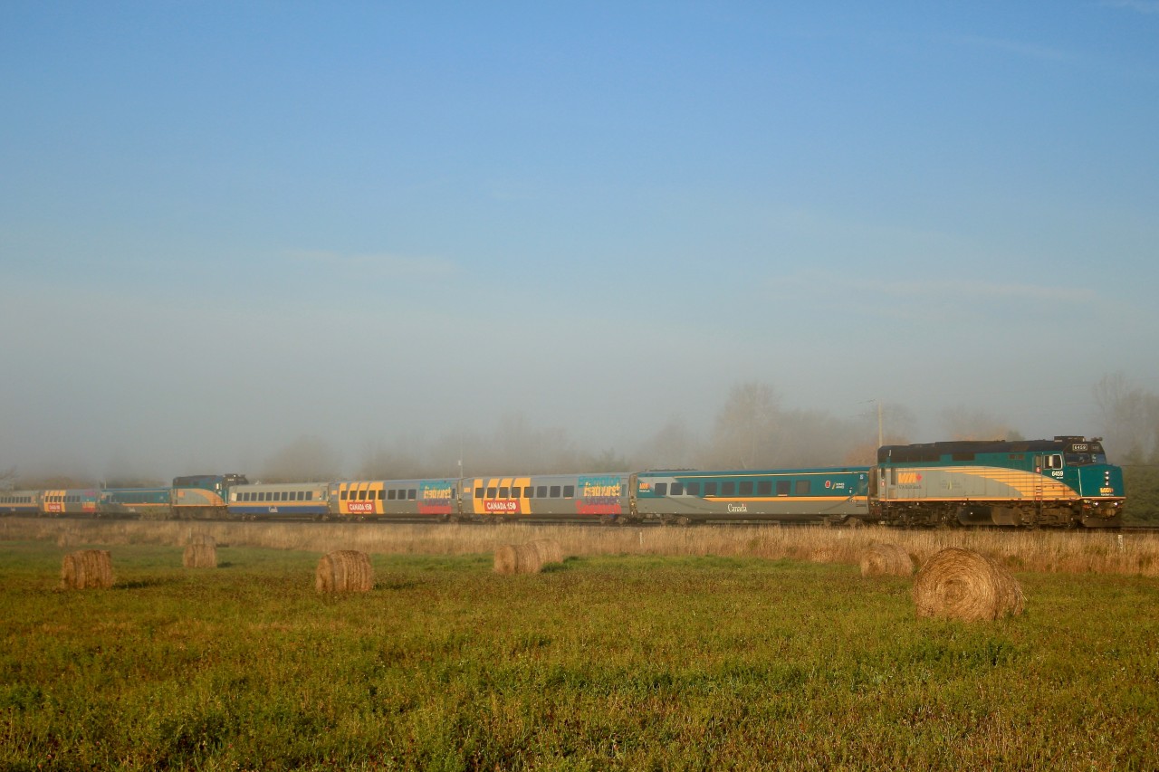 A morning splash of colour and equipment on a beautiful fall morning, VIA 50 / 60 combined consists to Montreal and Ottawa running through light fog just east of Belleville ON.